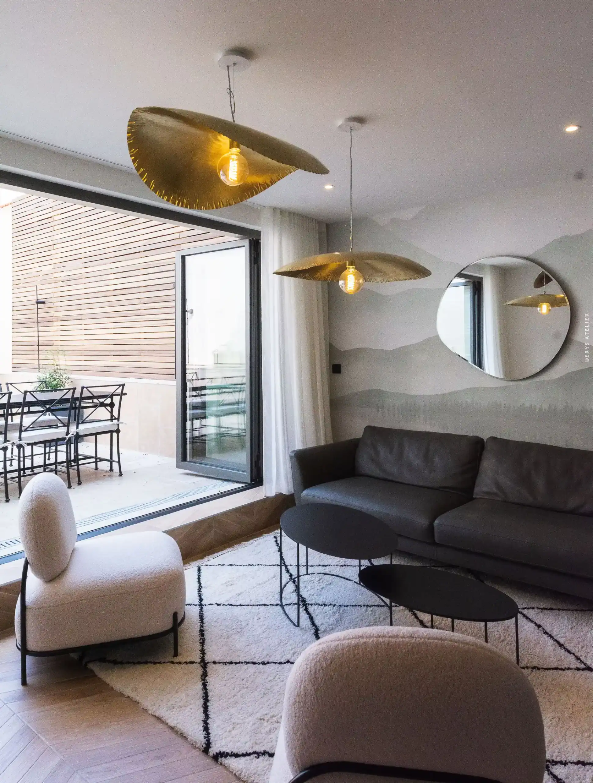 Lumière suspendue design dans un salon moderne avec vue sur terrasse.