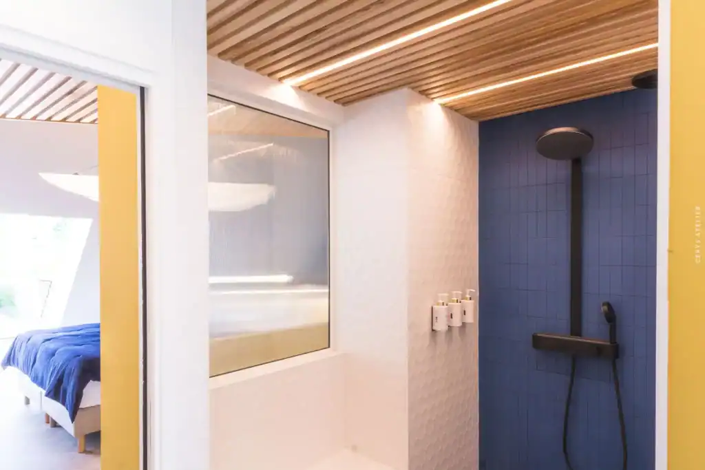 Salle de douche moderne avec carrelage bleu, chaleur et confort garantis.