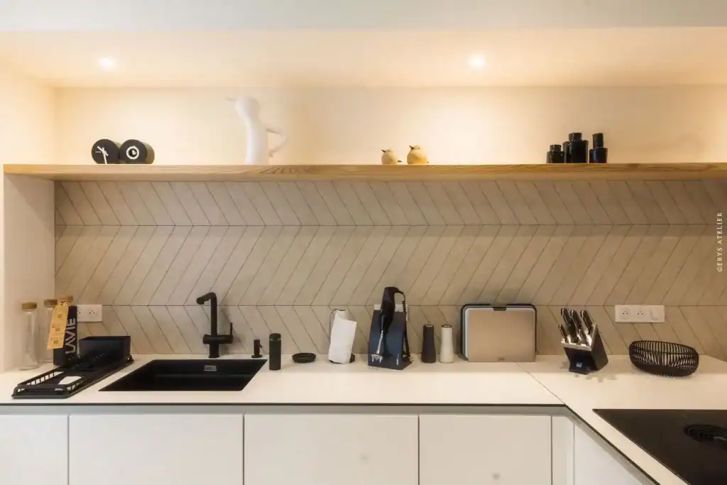 Évier noir, plan de travail blanc, décor moderne dans la cuisine de Clos Sainte Geneviève.