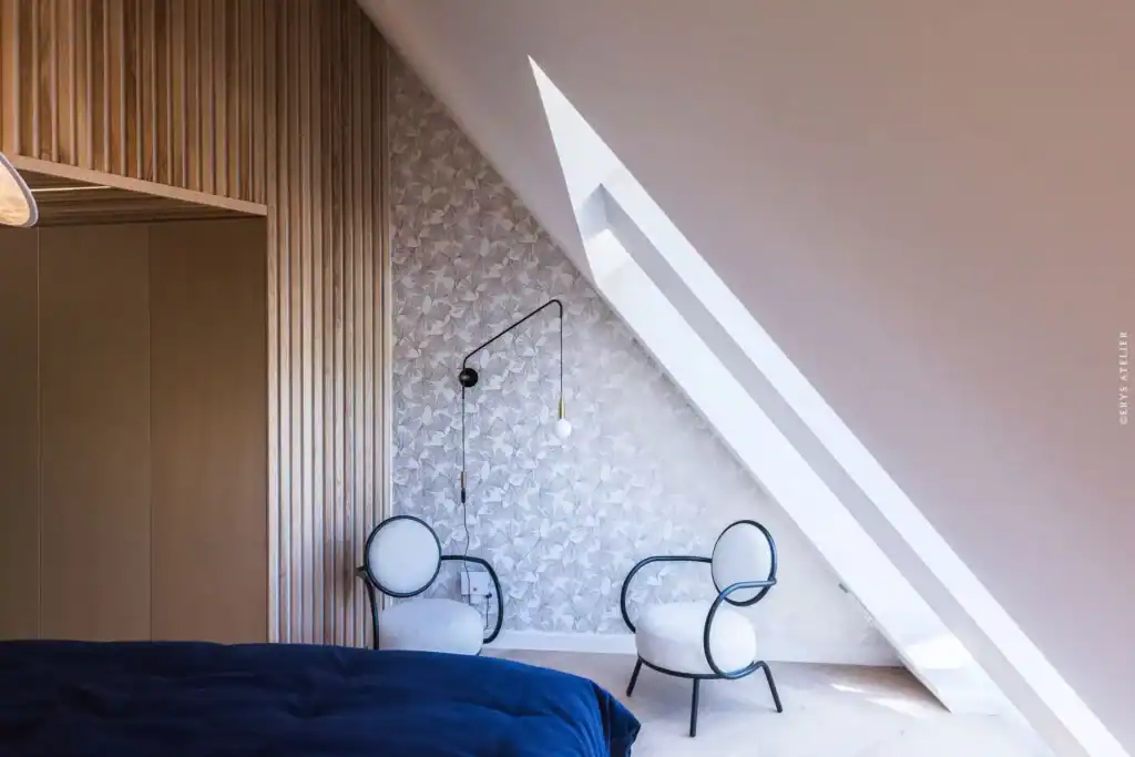 Chambre moderne sous toit avec fenêtres de toit et décoration épurée.