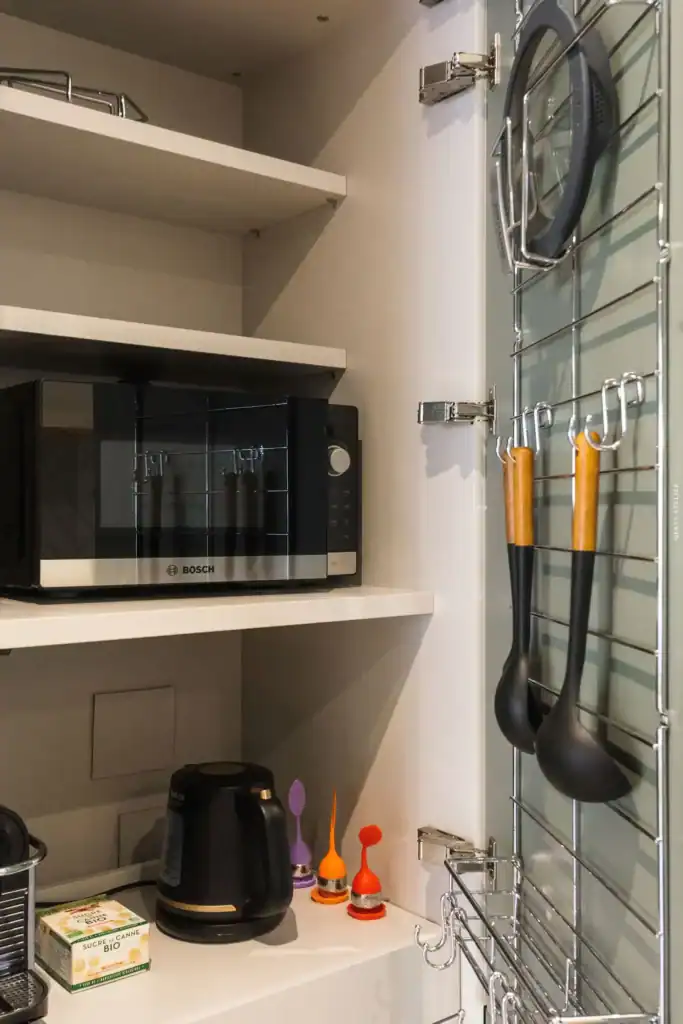 micro-ondes Bosch, ustensiles de cuisine suspendus, cuisine moderne bien organisée.