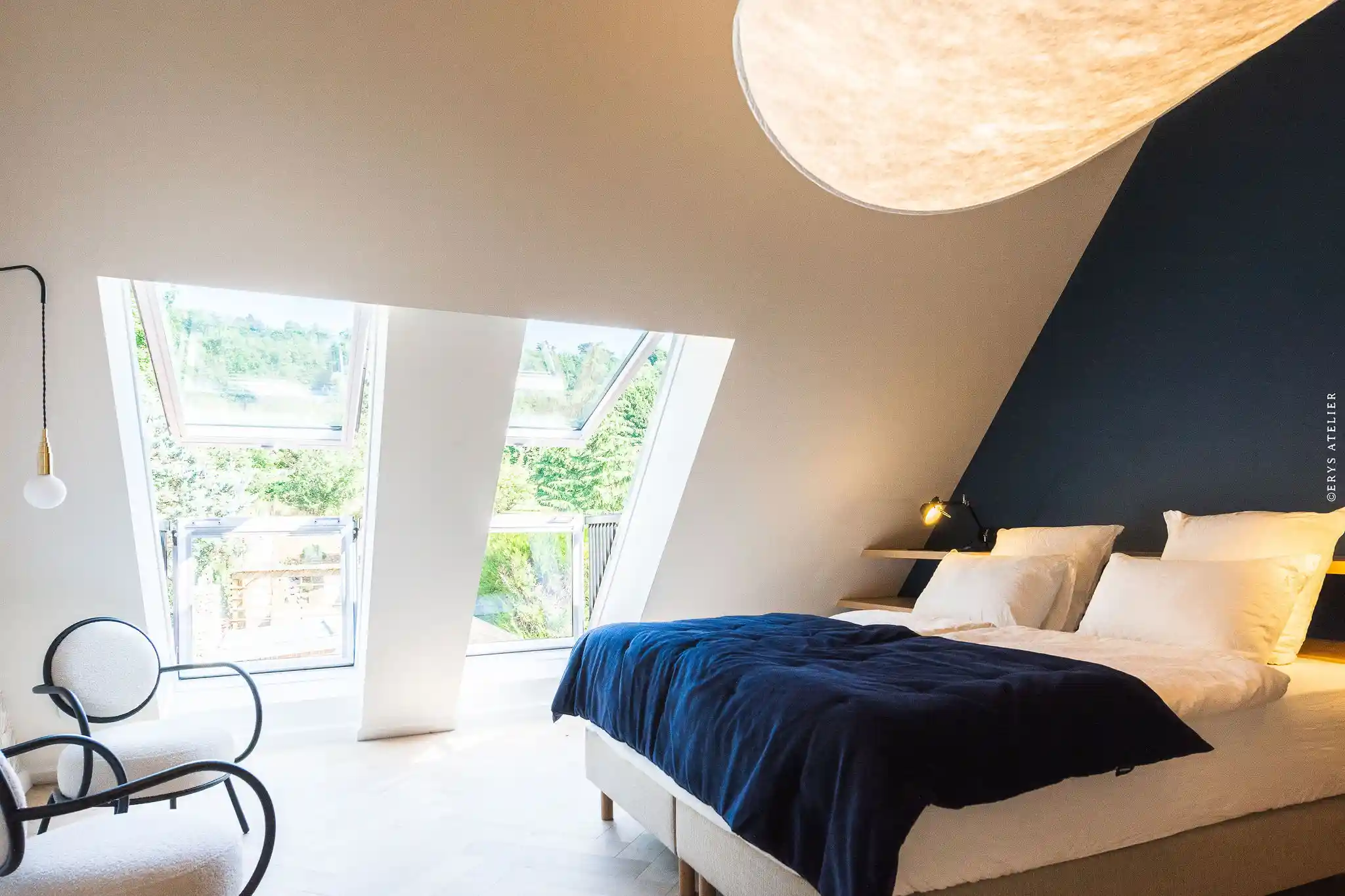 Chambre élégante avec lits confortables, décoration contemporaine et éclairage chaleureux.