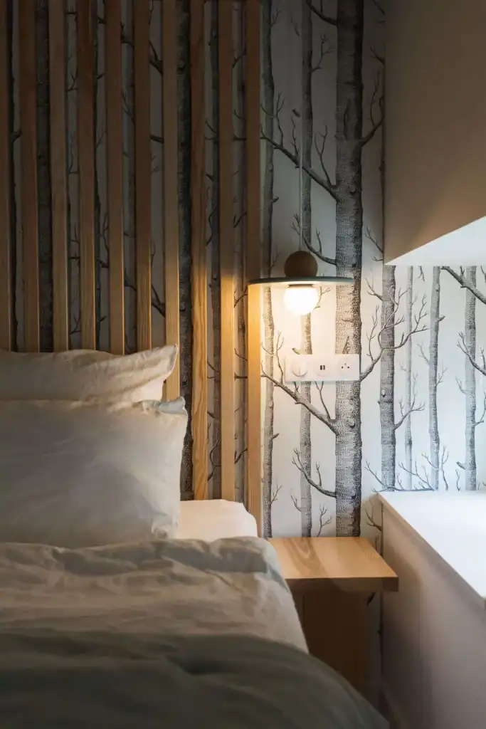 Calme et confort dans une chambre chaleureuse avec décoration murale végétale en bois naturel.