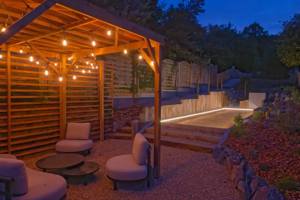 terrain de pétanque et Salon de jardin sous pergola de nuit au clos saint geneviève