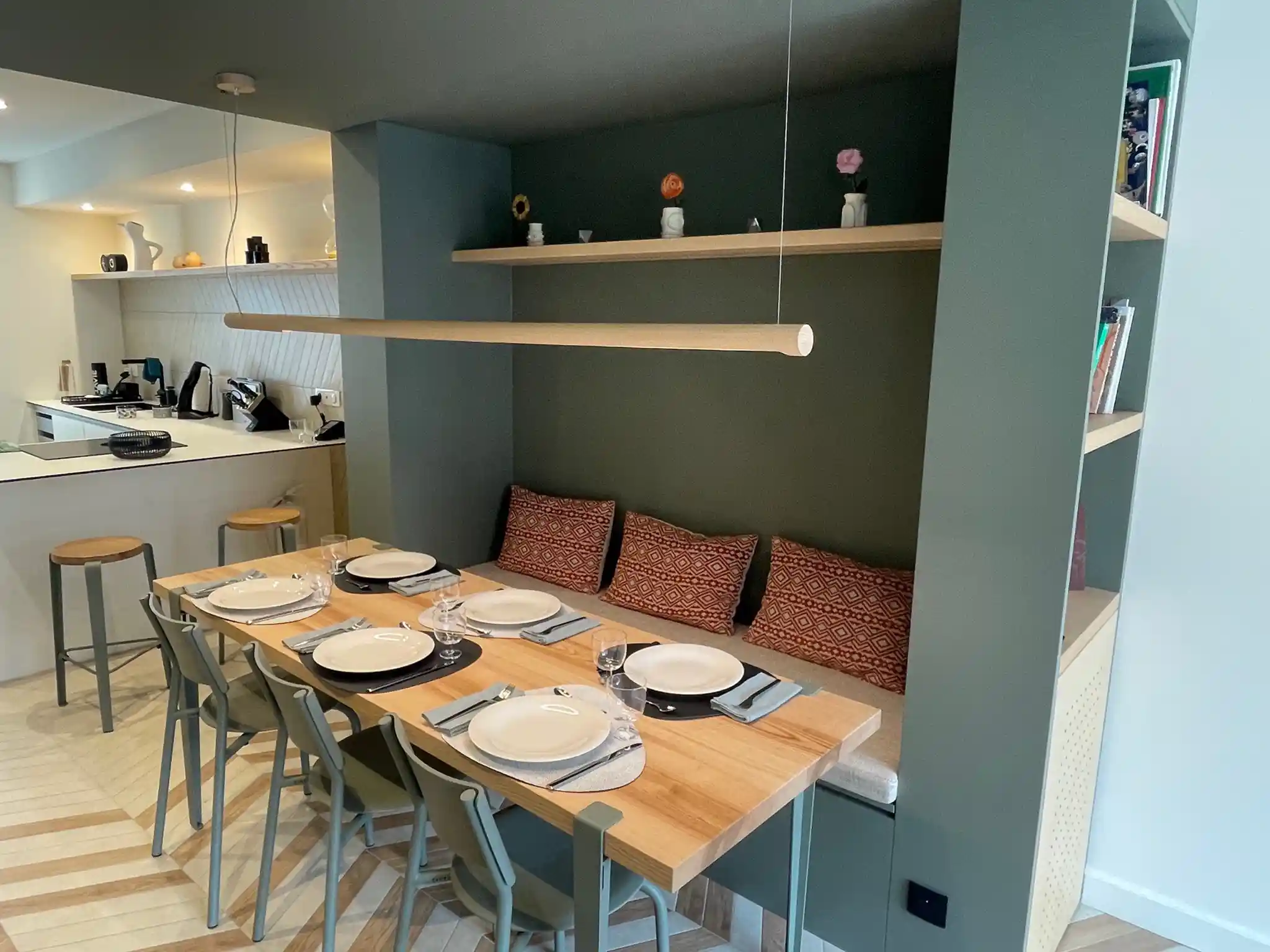 Décoration intérieure moderne avec table à manger élégante et assiettes prêtes pour un dîner convivial.