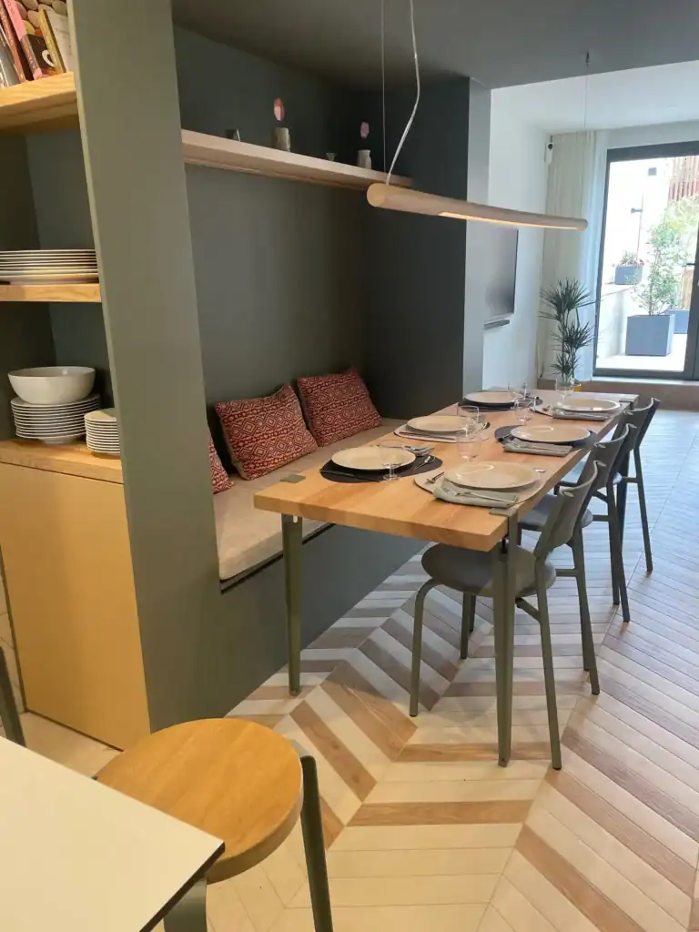 Moderne salle à manger avec mobilier en bois et décor épuré, vue sur un balcon avec plantes.