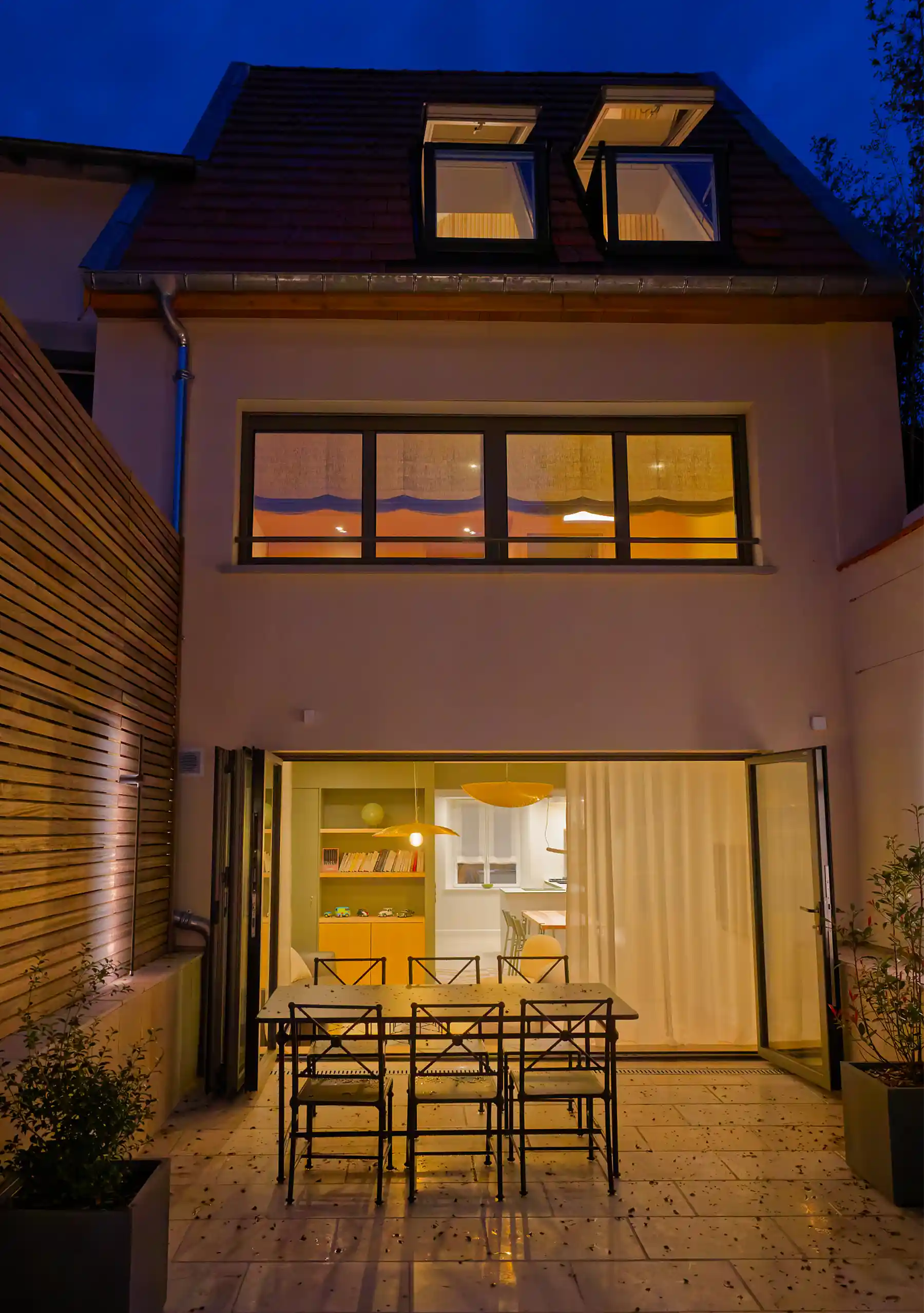 façade arrière avec terrasse illuminée, vue sur la maison et intérieur chaleureux à Dommartemont.